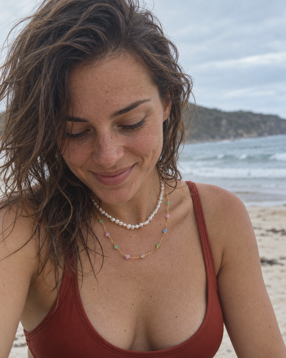 Whitewash and Pastel Tide necklaces worn in a candid beach portrait.
