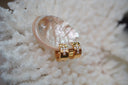 Broad gold-tone hoop earrings with clear accents arranged in crosses on the front.