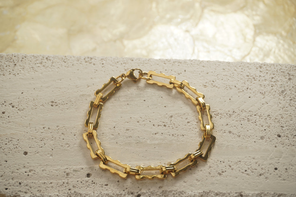Gold-tone bracelet with open rectangular links, scalloped edges and smaller oval connectors.