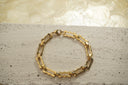 Gold-tone bracelet with open rectangular links, scalloped edges and smaller oval connectors.