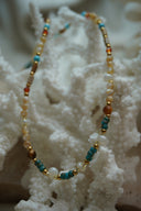 Alternate view: mixed-bead necklace with cream, white, blue and brown beads, cylindrical sections and gold-tone spacers.