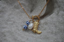 Alternate view: gold-tone chain necklace with a boot charm, white oval bead and blue-and-white patterned beads on a circular connector.