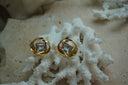Gold-tone stud earrings with clear square centres framed by flowing open circular curves.