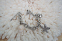 Alternate view: silver-tone link bracelet with a textured starfish, fan-shell motif and pale shell-shaped charm.