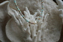 Alternate view: pale blue beaded necklace with mottled markings, gold-tone spacers and a larger white oval centre bead.