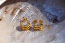 Gold-tone open hoop earrings formed from three parallel bands, with posts and butterfly backs.