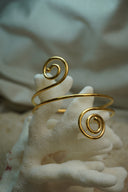 Alternate view: gold-tone open cuff with a sweeping slender band and two spiral ends.