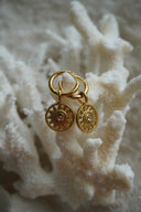 Gold-tone hoops with open sunburst disc charms, dotted borders and round clear centres.
