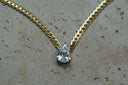 Alternate view: gold-tone textured chain necklace with a clear faceted teardrop centre.