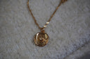 Alternate view: gold-tone necklace with a western hat pendant, curved brim, bow detail and twisting chain.