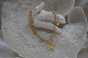 Layered gold-tone necklace with a large detailed butterfly, smaller butterfly charms and a flat upper strand.