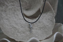 Silver-tone revolver-shaped pendant with patterned edges on a black necklace cord.