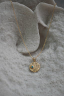 Alternate view: gold-tone necklace with a textured circular pendant, blue-centred sun and small clear accents.