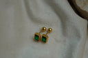 Gold-tone rectangular studs with green faceted centres, ribbed borders, straight posts and ball backs.