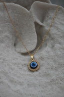 Alternate view: gold-tone necklace with a blue-and-white eye disc pendant bordered by clear round accents.