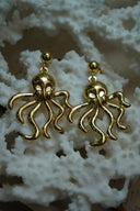 Gold-tone octopus drop earrings with curling tentacles beneath smooth ball studs.