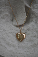 Alternate view: gold-tone necklace with a smooth rounded heart pendant and a fine chain with twisted-looking links.