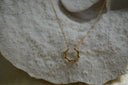 Gold-tone necklace with an open scalloped halo shape attached to a fine chain.
