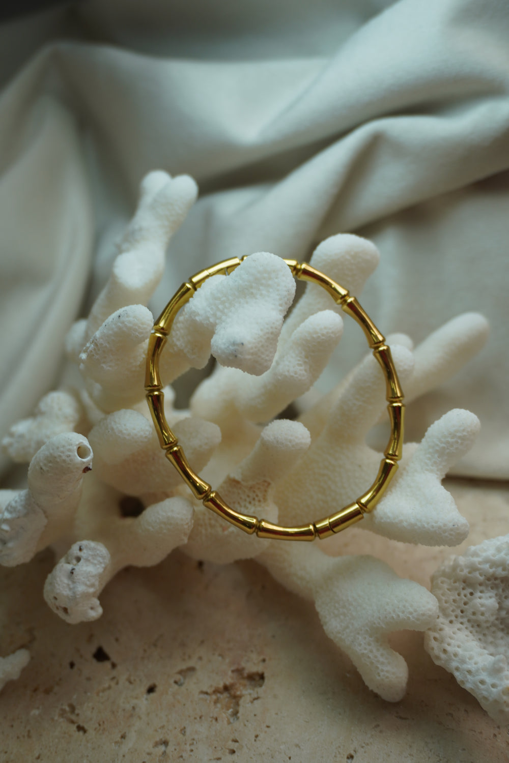 Alternate view: gold-tone bangle with rounded segmented sections and a bamboo-inspired pattern.