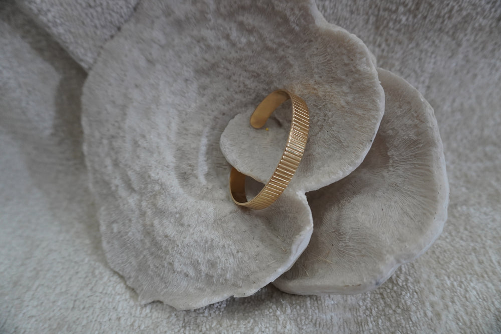 Alternate view: gold-tone open cuff with closely spaced vertical ridges across a flat band.