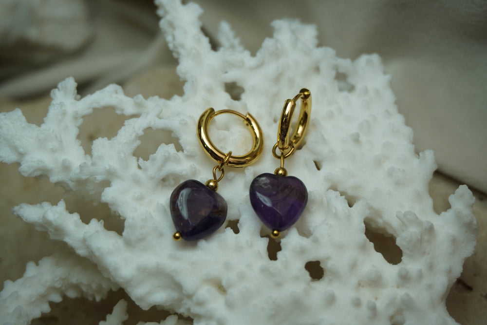 Alternate view: gold-tone hoop earrings with deep purple heart-shaped bead drops and small gold-tone ball details.