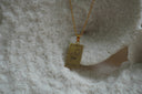 Gold-tone necklace with a rectangular The Empress pendant, crown and circle-cross illustration, and III lettering.