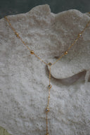 Alternate view: gold-tone Y necklace with small spherical beads and clear round accents along the chain and drop.
