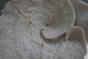 Gold-tone Y necklace with small spherical beads and clear round accents along the chain and drop.