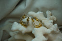 Alternate view: gold-tone rounded triangular hoops with alternating ridged sections and rows of clear accents.