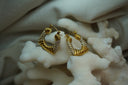 Gold-tone rounded triangular hoops with alternating ridged sections and rows of clear accents.
