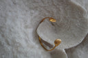 Alternate view: slender gold-tone open cuff with a ridged shell shape at each end.