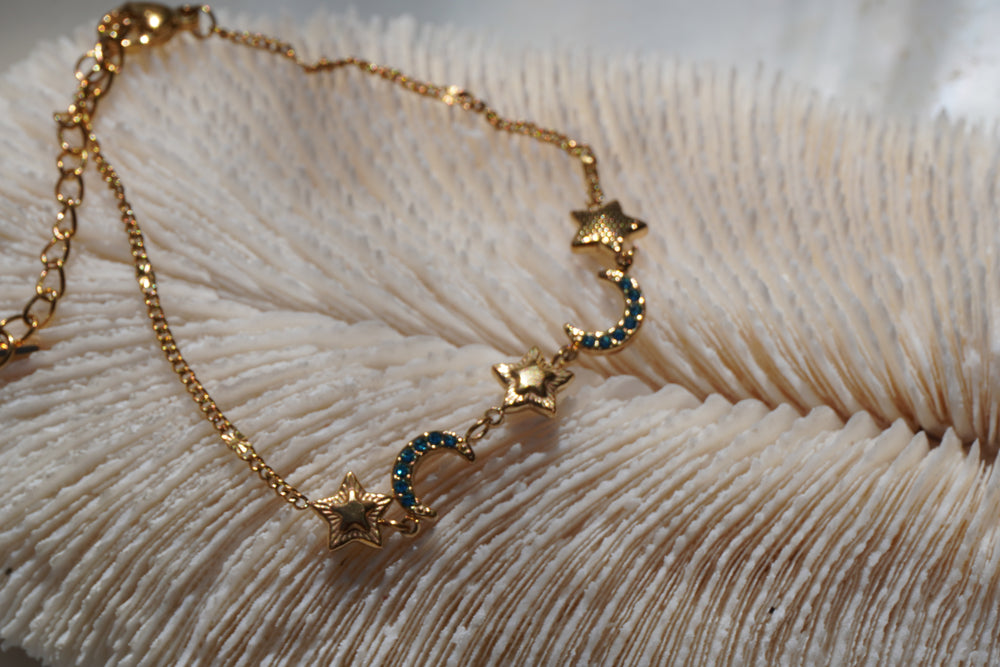 Alternate view: gold-tone fine-chain bracelet with stars and blue-accented crescent moons.
