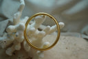 Gold-tone ribbed bracelet with a smooth cylindrical clasp.