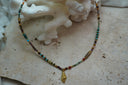 Alternate view: fine multicoloured bead necklace with a gold-tone spiral-shell charm and an asymmetric brown cylindrical bead.