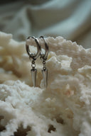 Silver-tone hoop earrings with rounded connectors and slim tapered pointed drops.