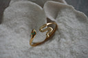 Alternate view: gold-tone snake-shaped open cuff with green eyes and a curved tail.