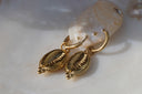 Alternate view: gold-tone hoop earrings with cowrie-shaped hanging charms, ridged openings and dotted borders.