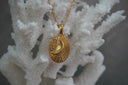 Alternate view: gold-tone oval pendant necklace with a raised crescent moon, radiating lines and clear accents.