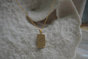 Gold-tone necklace with a rectangular The Sun pendant, sun-face illustration, pointed rays and XIX lettering.