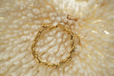 Gold-tone bracelet with chunky interlocking oval links, diagonal markings and an extension chain.