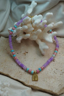 Alternate view: purple, pink and blue bead necklace with gold-tone spacers and an arched palm-tree and wave charm.