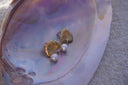 Alternate view: gold-tone fan-shaped leaf earrings with radiating lines, small stems and white bead drops.