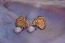 Gold-tone fan-shaped leaf earrings with radiating lines, small stems and white bead drops.