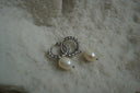 Alternate view: silver-tone twisted hoop earrings with hanging pale oval beads.