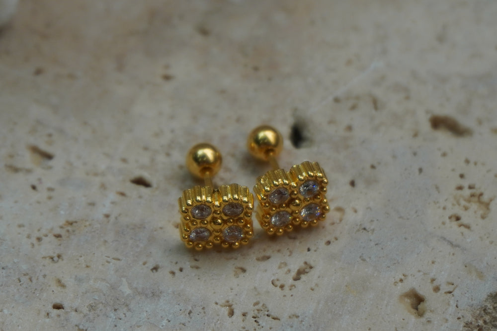 Gold-tone square studs with four round faceted accents, dotted borders and ribbed edges.