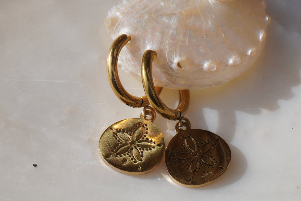 Alternate view: gold-tone hoop earrings with circular hanging discs and five-petal sand-dollar motifs.