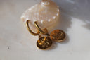 Gold-tone hoop earrings with circular hanging discs and five-petal sand-dollar motifs.