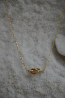 Alternate view: gold-tone necklace with a smooth central knot shape and fine oval-link chain.