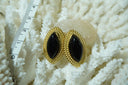 Earrings with glossy black pointed-oval centres and rope-like gold-tone borders.