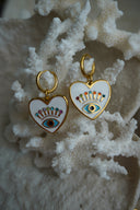 Gold-tone hoops with white heart charms, blue eye motifs and multicoloured accents.